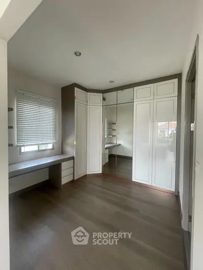 Spacious bedroom with built-in wardrobe and large window for natural light