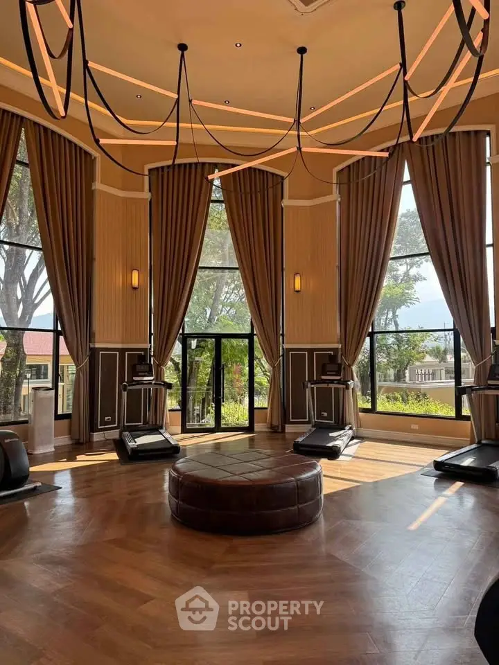 Luxurious gym with high ceilings, elegant drapery, and state-of-the-art equipment in a premium real estate property.