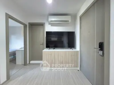 Modern apartment entrance with sleek TV setup and air conditioning, showcasing contemporary living space.
