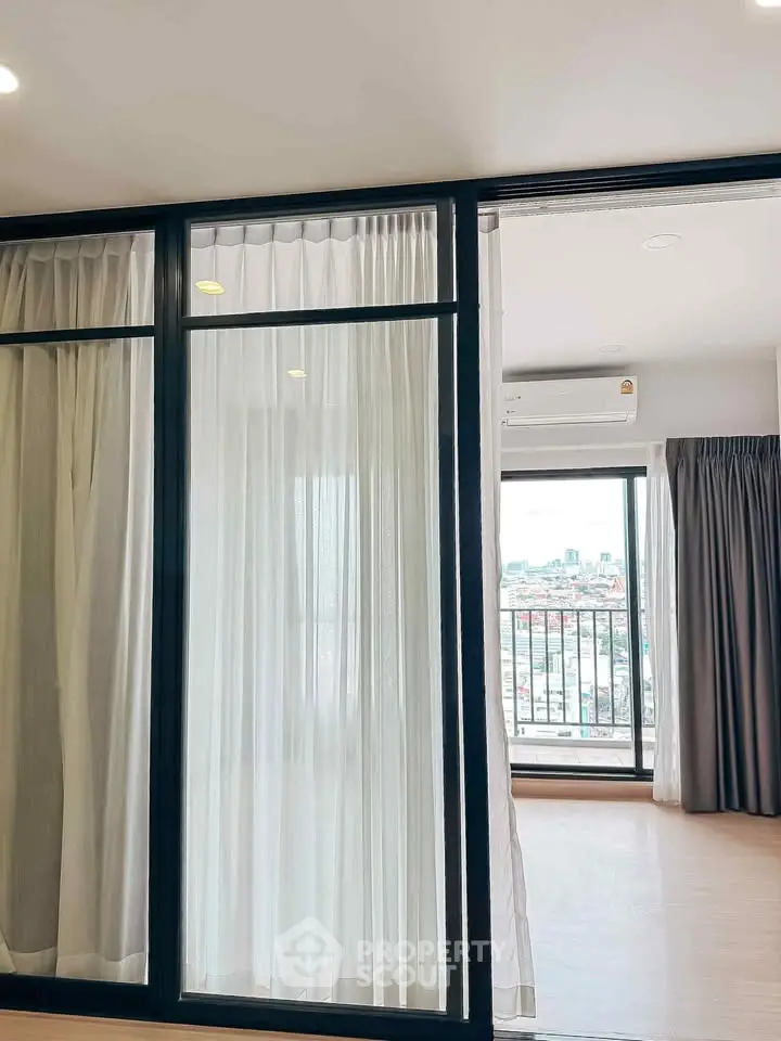 Spacious apartment with floor-to-ceiling windows and city view, featuring modern sliding glass doors and elegant curtains.
