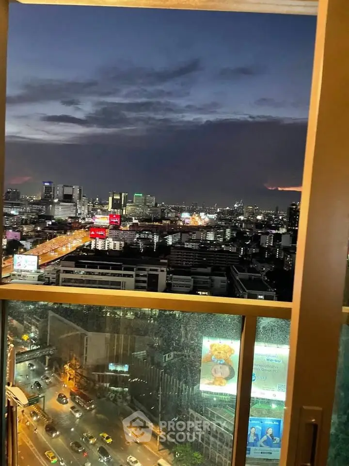 Stunning cityscape view from high-rise window at dusk, showcasing vibrant urban lights.