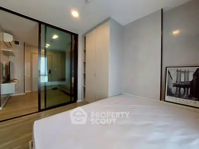 Modern bedroom with glass partition and stylish decor in a contemporary apartment.