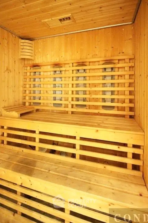 Luxurious wooden sauna room with warm lighting and comfortable seating, perfect for relaxation and wellness.