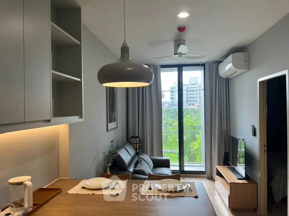 Modern living room with balcony view, stylish furniture, and open layout in urban apartment.