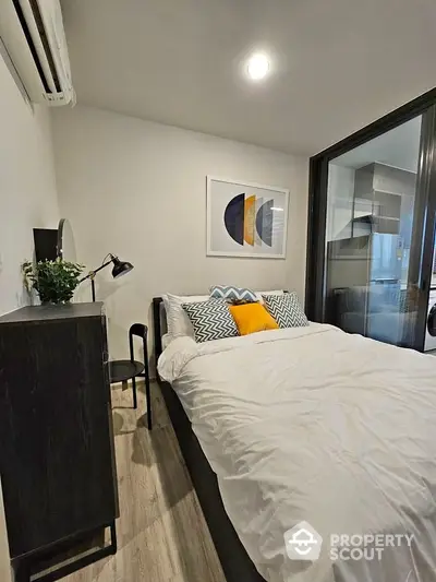 Modern bedroom with stylish decor and cozy ambiance, featuring contemporary artwork and sleek furniture.