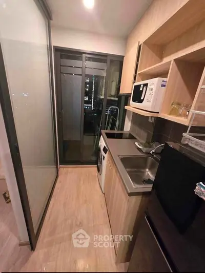 Modern compact kitchen with sleek appliances and city view