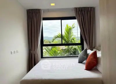 Cozy bedroom with large window offering lush green views, perfect for relaxation and tranquility.
