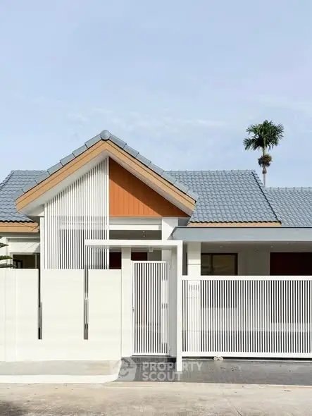 Modern minimalist house exterior with sleek white fence and blue roof