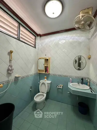 Spacious bathroom with modern fixtures and natural light, featuring a shower and elegant tile design.