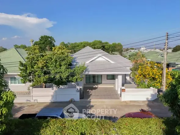 Charming suburban house with lush greenery and spacious driveway, perfect for family living.