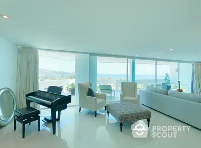 Luxurious open-plan living room with panoramic ocean views, elegant furnishings, and a grand piano, perfect for upscale coastal living.