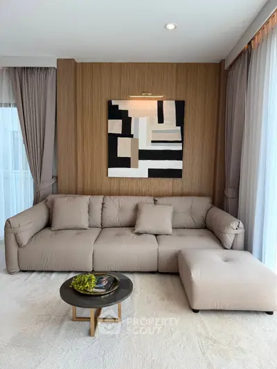 Modern living room with stylish sofa and abstract art, featuring elegant curtains and cozy ambiance.