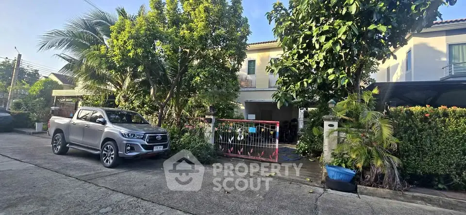 Charming suburban house with lush greenery and parked car in driveway