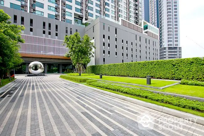 Modern urban building exterior with landscaped garden and driveway