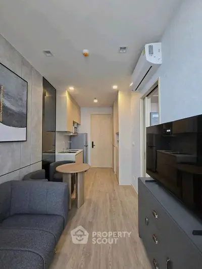 Modern living room with sleek furniture and open kitchen layout in a stylish apartment.