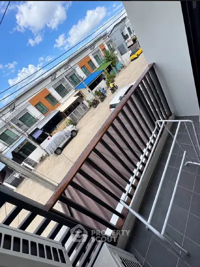Charming balcony view of modern townhouses with clear blue skies.