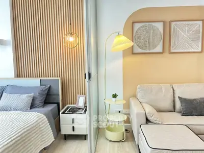 Modern living room with cozy bedroom, stylish decor, and elegant lighting in open-concept apartment.