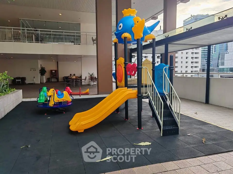 Modern apartment building with vibrant children's playground and city view.