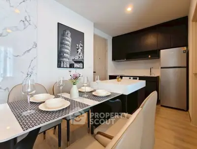 Modern kitchen with dining area featuring sleek black cabinets and elegant marble accents.