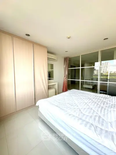 Bright and airy bedroom with large mirrored wardrobe and modern furnishings