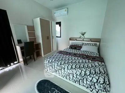 Modern bedroom with stylish decor, featuring a cozy bed, wardrobe, and study desk, perfect for comfortable living.