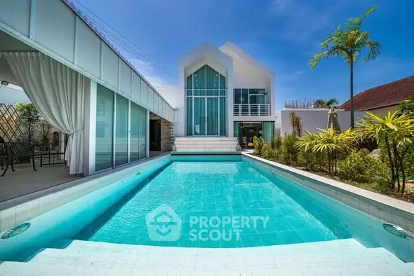 Luxurious modern villa with stunning pool and elegant architecture under clear blue sky.