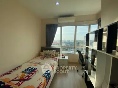 Cozy bedroom with city view, featuring a single bed, desk, and large window for natural light.
