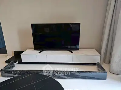 Modern living room with sleek TV stand and flat-screen TV, perfect for entertainment.