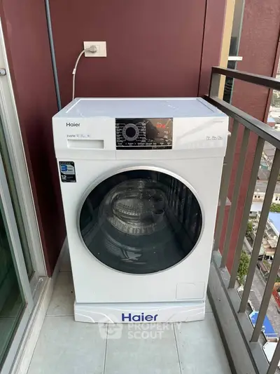 Modern washing machine on a balcony with city view, perfect for urban living convenience.