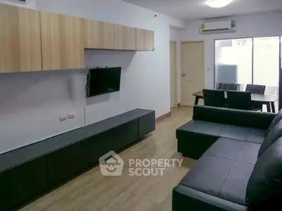 Modern living room with sleek furniture and wall-mounted TV, perfect for urban living.