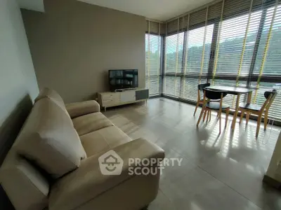 Modern living room with large windows and stylish furniture, offering a bright and inviting atmosphere.