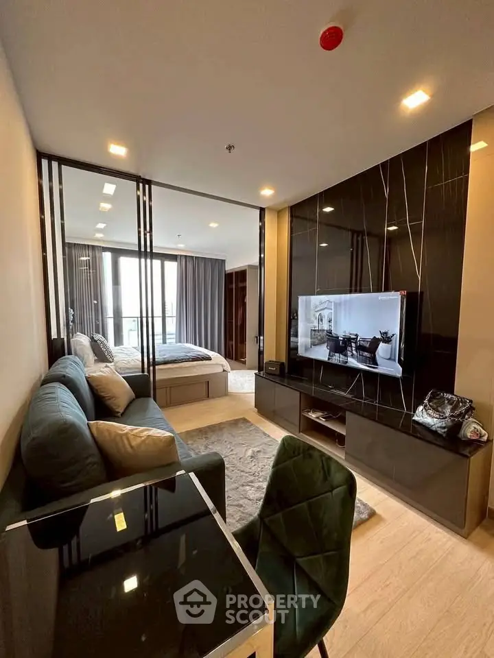 Modern open-plan living room with sleek furniture and integrated bedroom view.