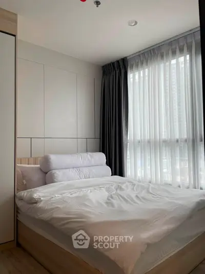 Modern bedroom with large window and stylish decor in urban apartment