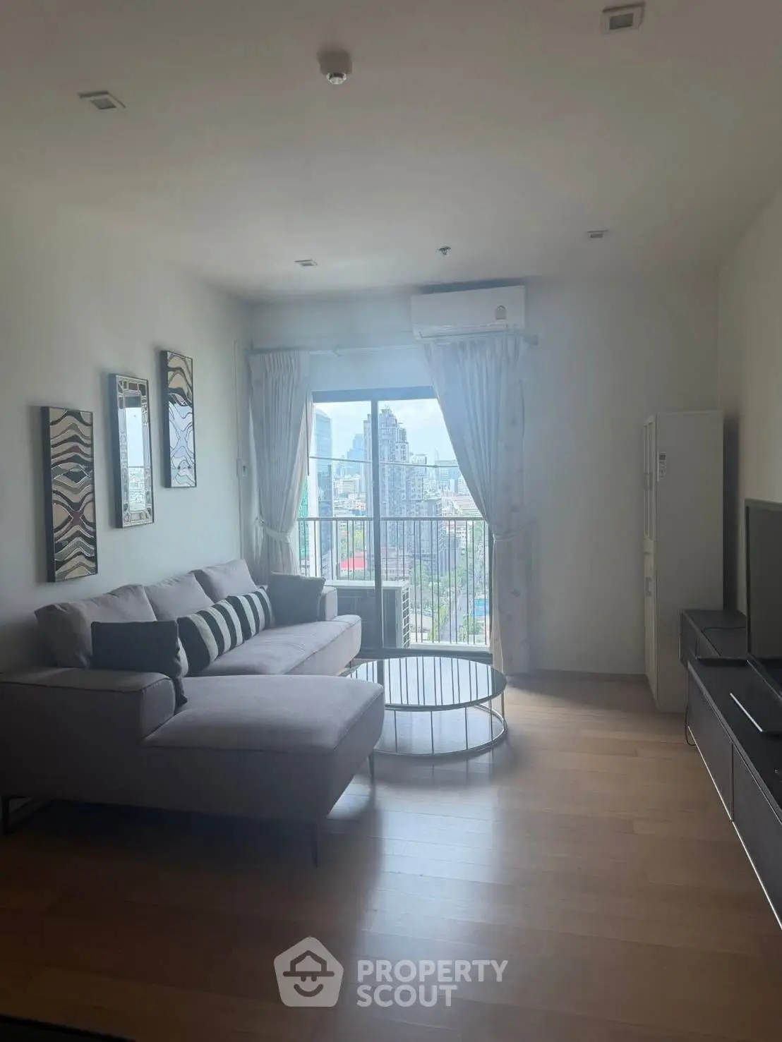 Spacious living room with modern decor and city view from balcony.