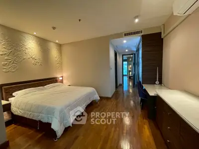 Spacious bedroom with elegant decor and wooden flooring in modern apartment