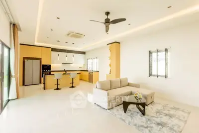 Spacious open-plan living room and kitchen with modern design and natural light.