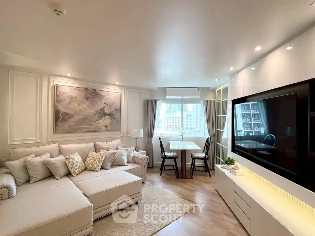 Elegant living room with modern decor and large TV, perfect for relaxation.