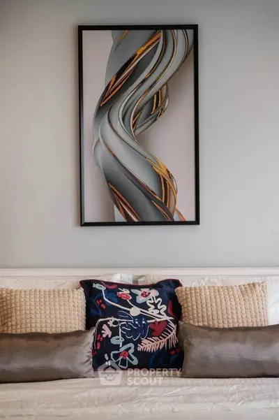 Stylish living room with modern art and decorative pillows on a cozy sofa.