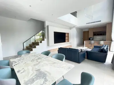 Luxurious open-plan living room with modern furniture and elegant marble dining table.