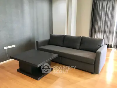 Modern living room with sleek gray sofa and wooden flooring