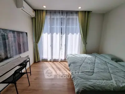 Bright bedroom with large window, green curtains, and modern furnishings.