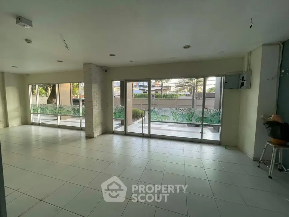 Spacious commercial space with large windows and tiled flooring, ideal for retail or office use.