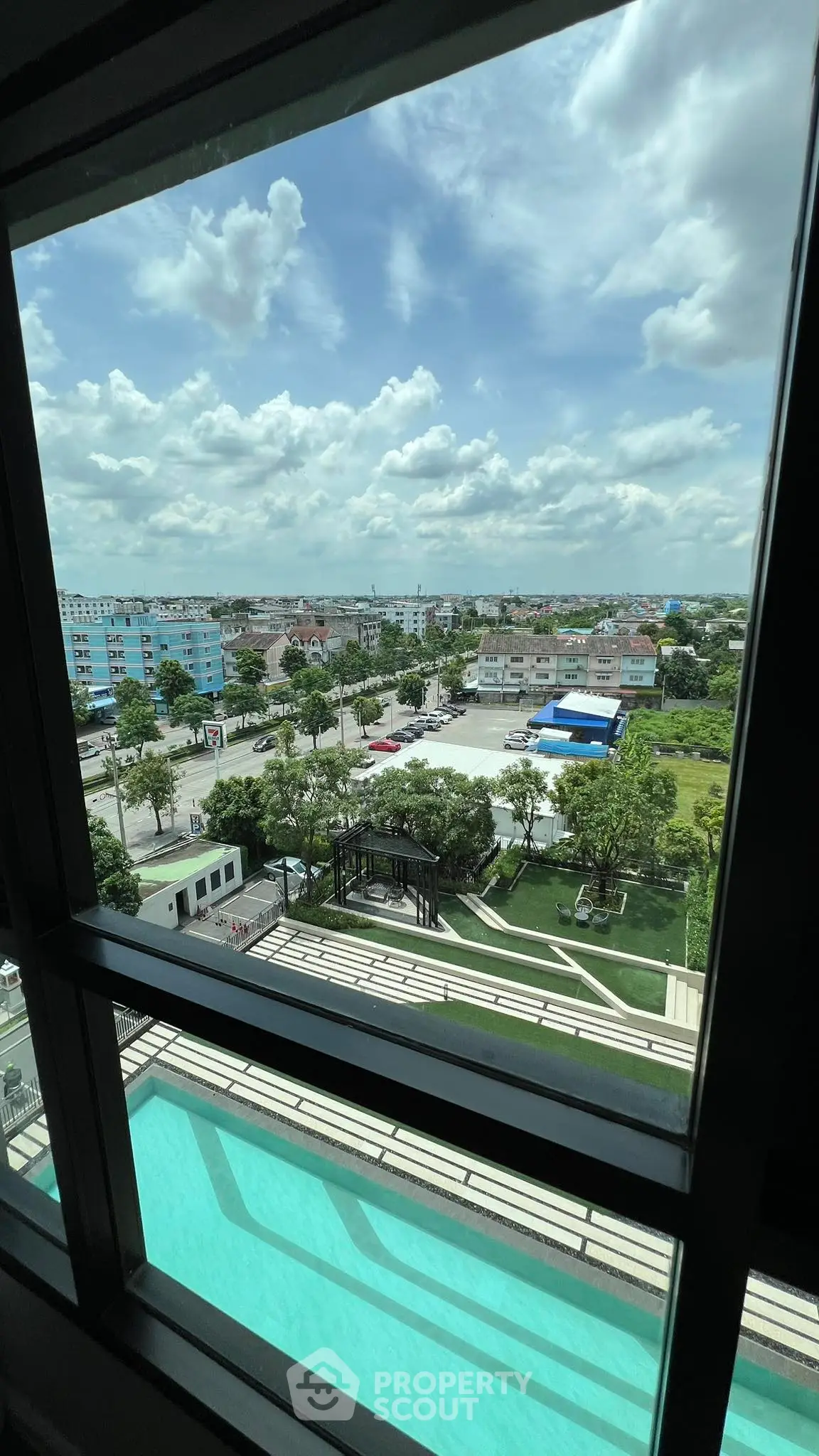 Stunning high-rise view with pool and cityscape under a vibrant sky.