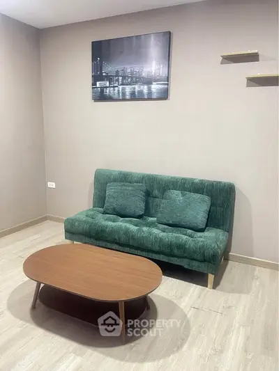 Cozy living room with green sofa and modern coffee table, perfect for relaxation.