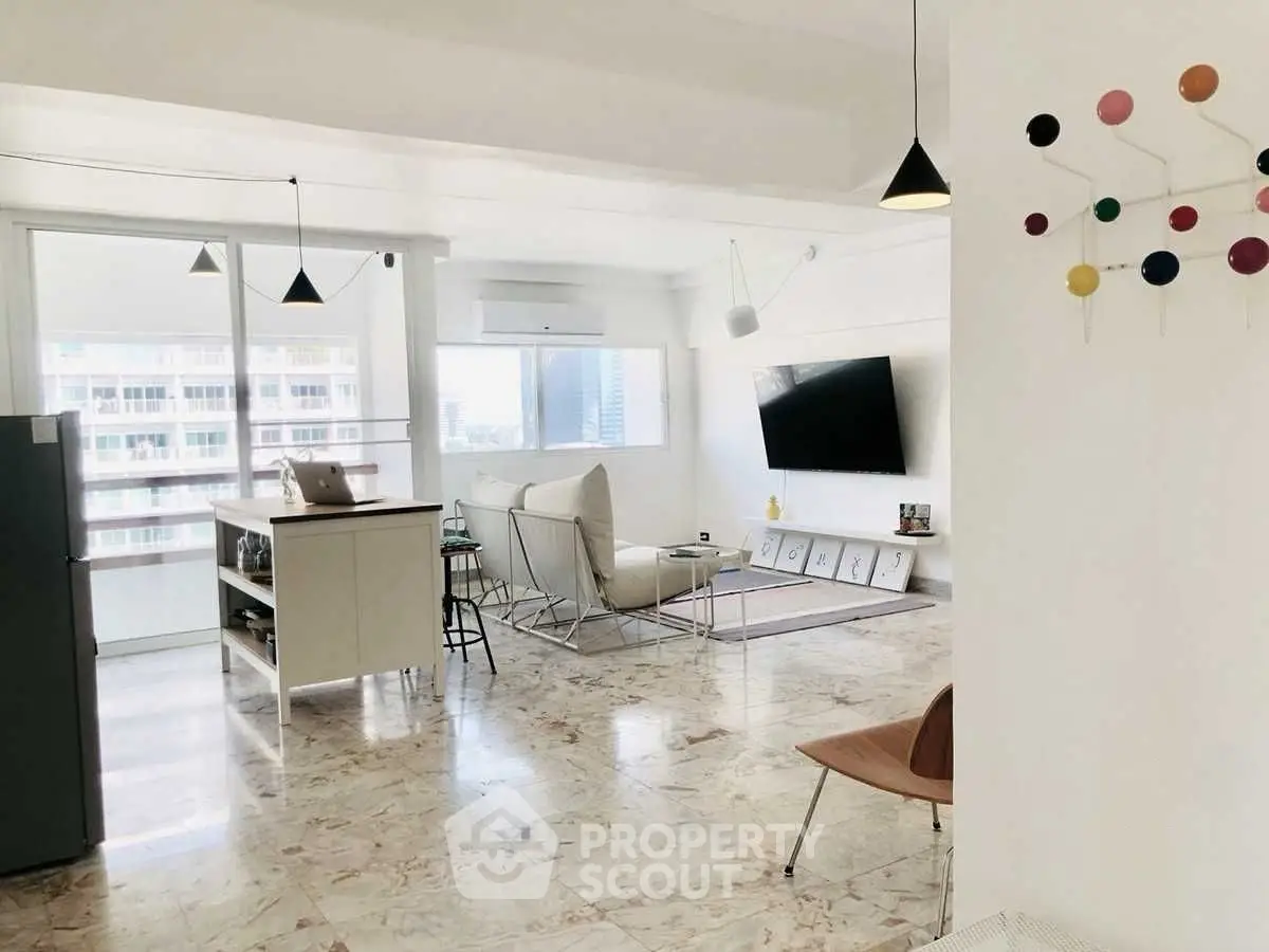 Spacious modern living room with stylish decor and large windows offering city views.