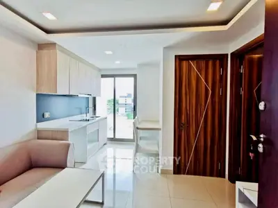 Modern open-layout living room with sleek kitchen and natural light