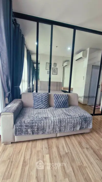 Modern living room with stylish sofa and floor-to-ceiling windows in a chic apartment.