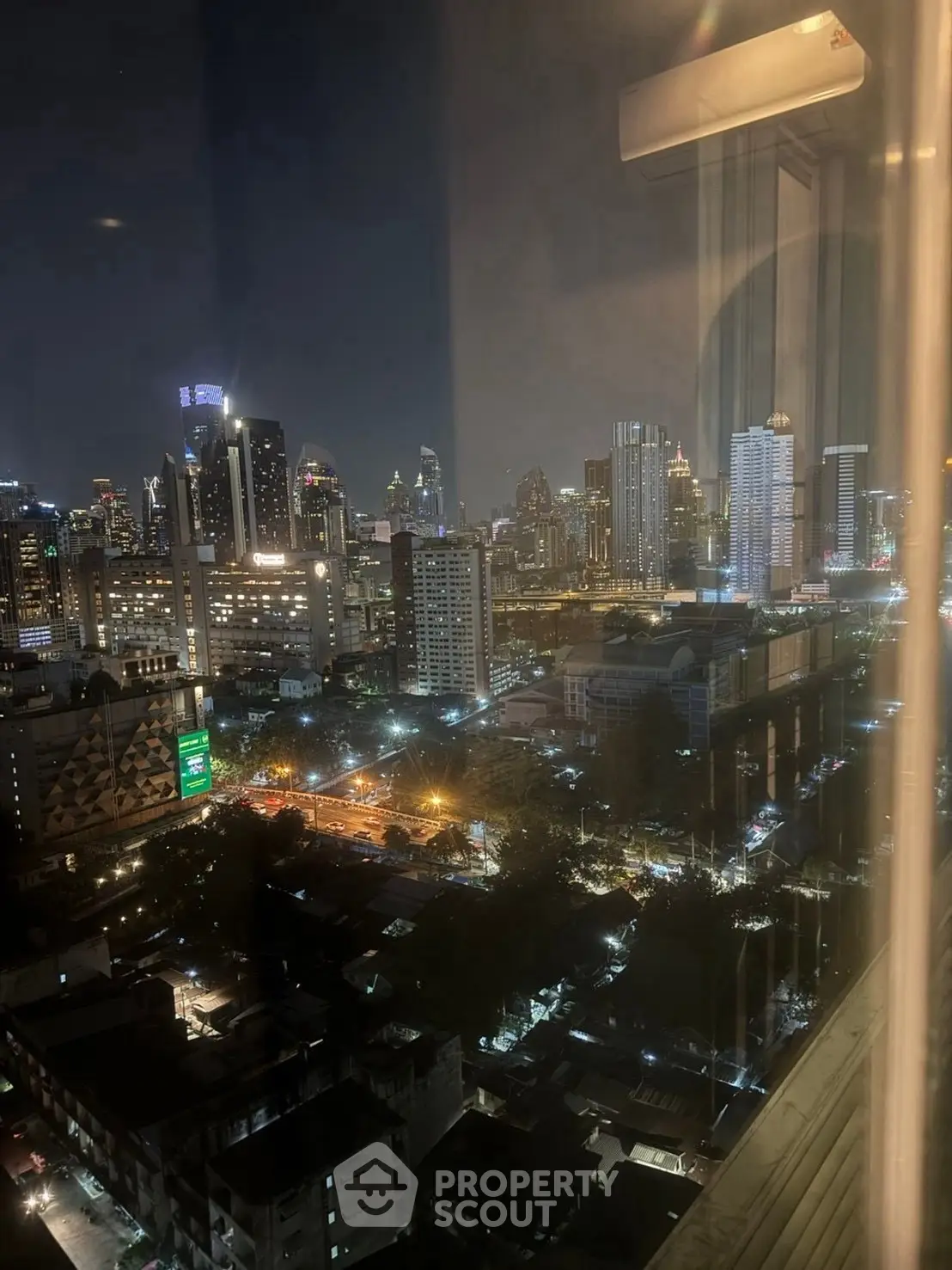 Stunning cityscape night view from high-rise apartment window.