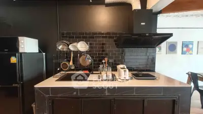 Modern kitchen with sleek black backsplash and appliances, featuring a stylish open layout.