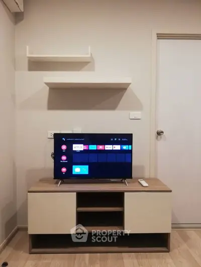 Modern living room with sleek TV stand and wall-mounted shelves, perfect for cozy entertainment setup.